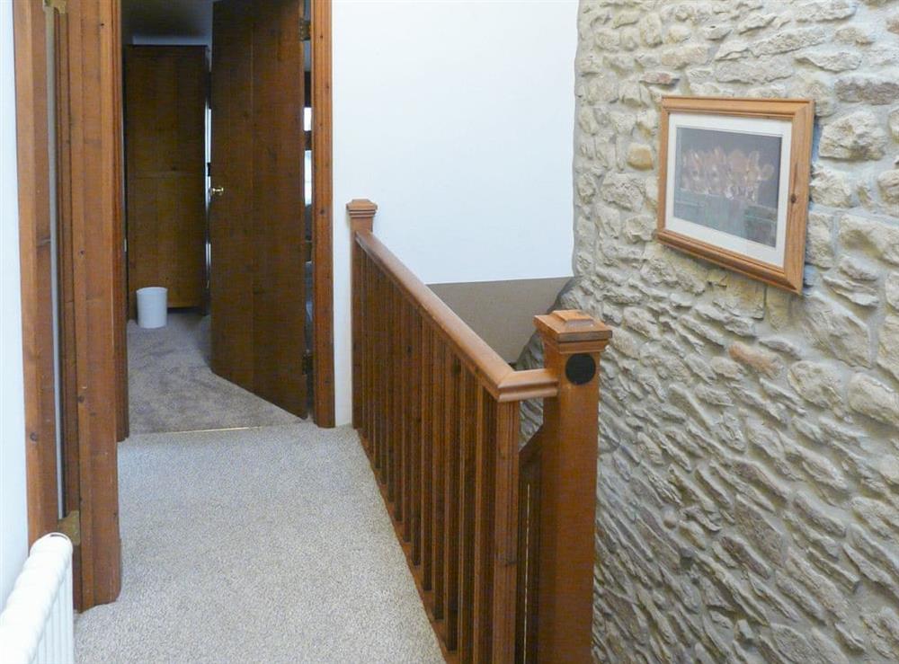 The stairs lead up to a landing with origional stone walls