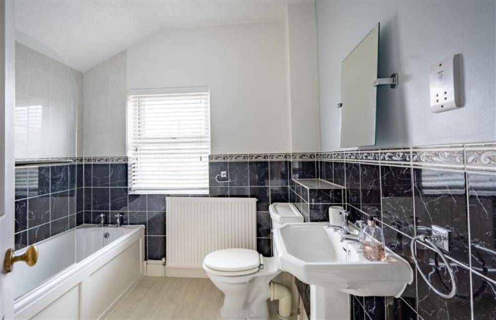First floor: Bathroom with shower over bath at Holly Cottage, Heacham near Kings Lynn
