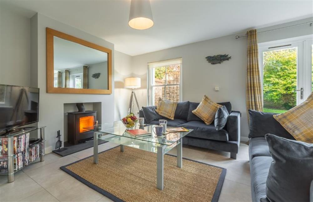 Ground floor: Wood burning stove and french windows at Holly Lodge, Wells-next-the-Sea