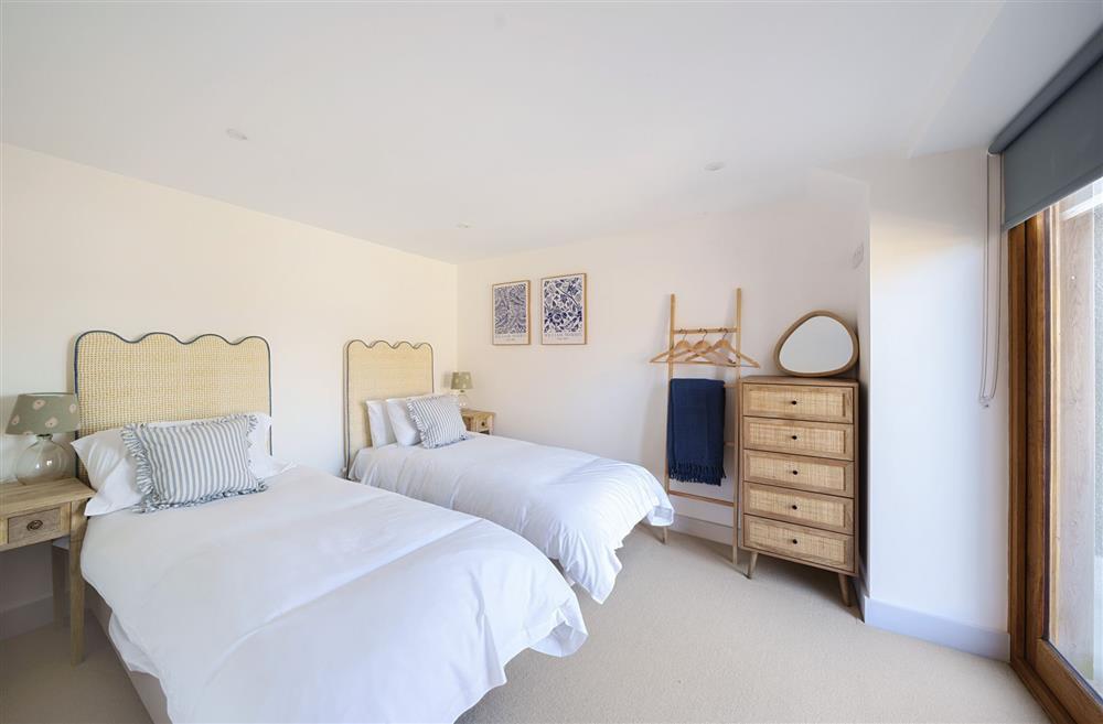 The ground floor twin bedroom with 2’6 single beds and door to the patio at Hollybank Barn, Dorchester