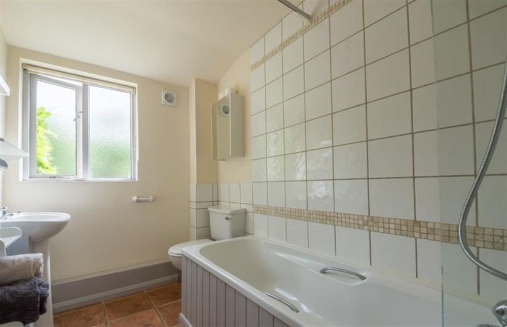 Ground floor: Family bathroom has bath with shower over (photo 2) at Hollyhock, Houghton near Kings Lynn
