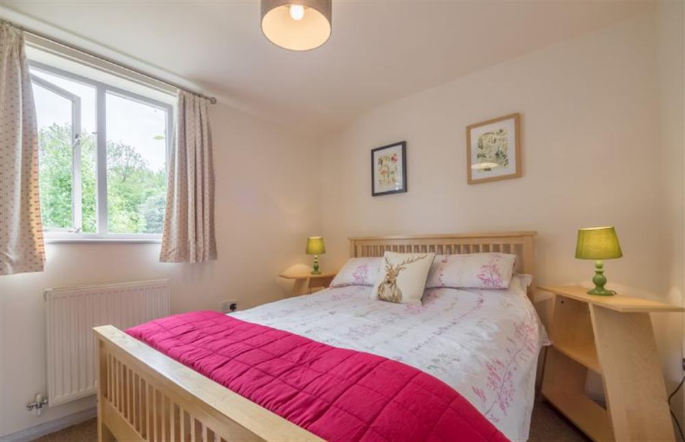 Ground floor: Master bedroom with double bed at Hollyhock, Houghton near Kings Lynn