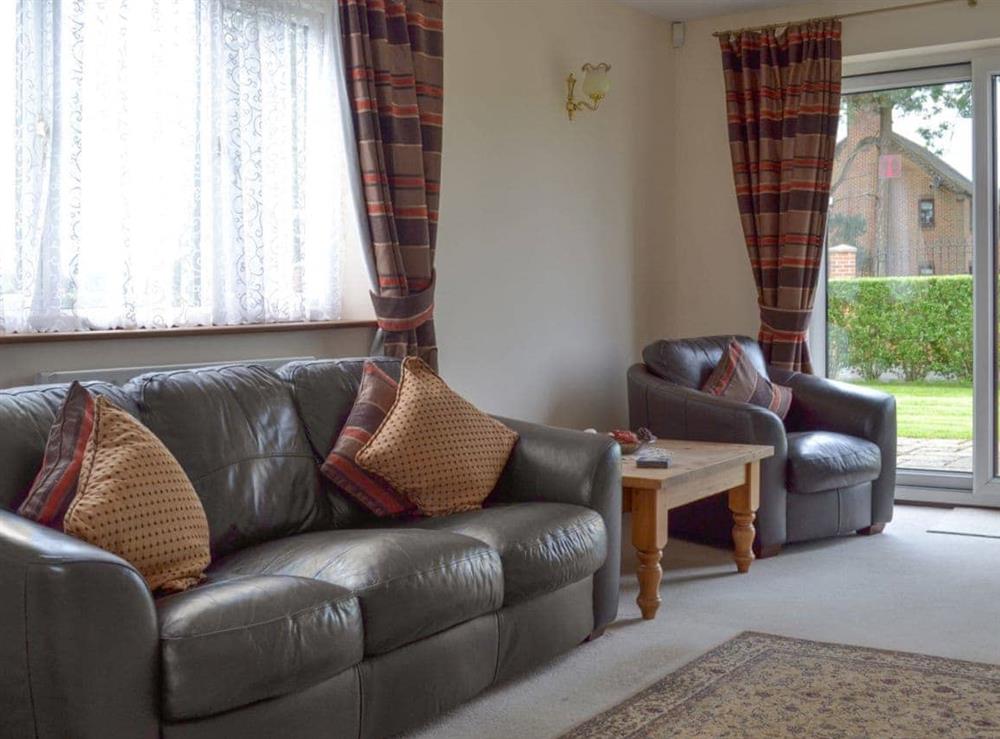 Comfortable leather furniture and patio doors leading to garden at Holme View in Clifton, near Ashbourne, Derbyshire
