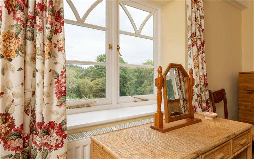 Bedroom one enjoys views over the grounds. at Holne Chase Carriage House in Ashburton