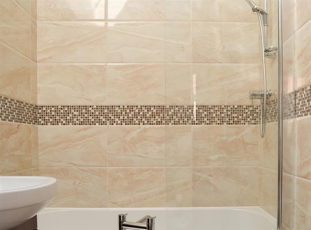 Beautifully tiled bathroom with shower over the bath at Cozy Cottage, 