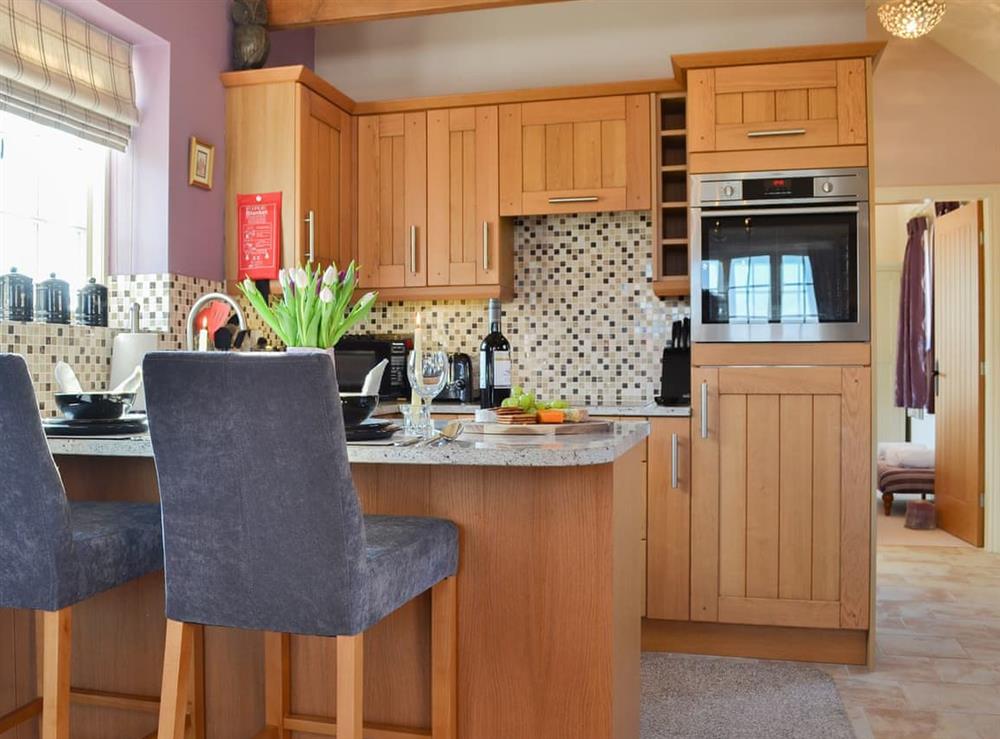 Modest kitchen with granite-topped breakfast bar at Cozy Cottage, 
