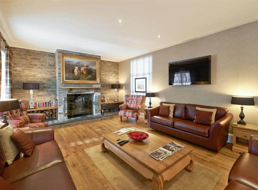 The spacious open plan living space offers a wood-burning stove at The Coach House, 