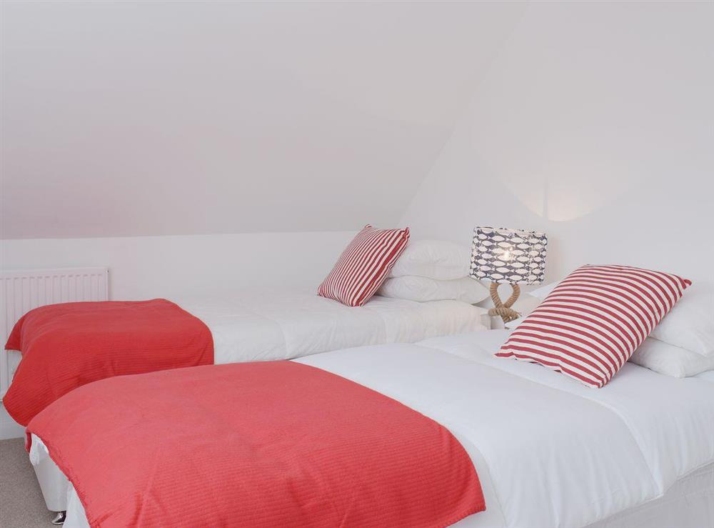 The twin bedded room has sloping ceilings and bright white walls