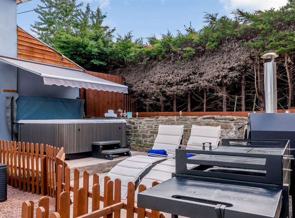 Outdoor area with Jacuzzi hot tub at Honeycott in Llangattock, near Crickhowell, Powys