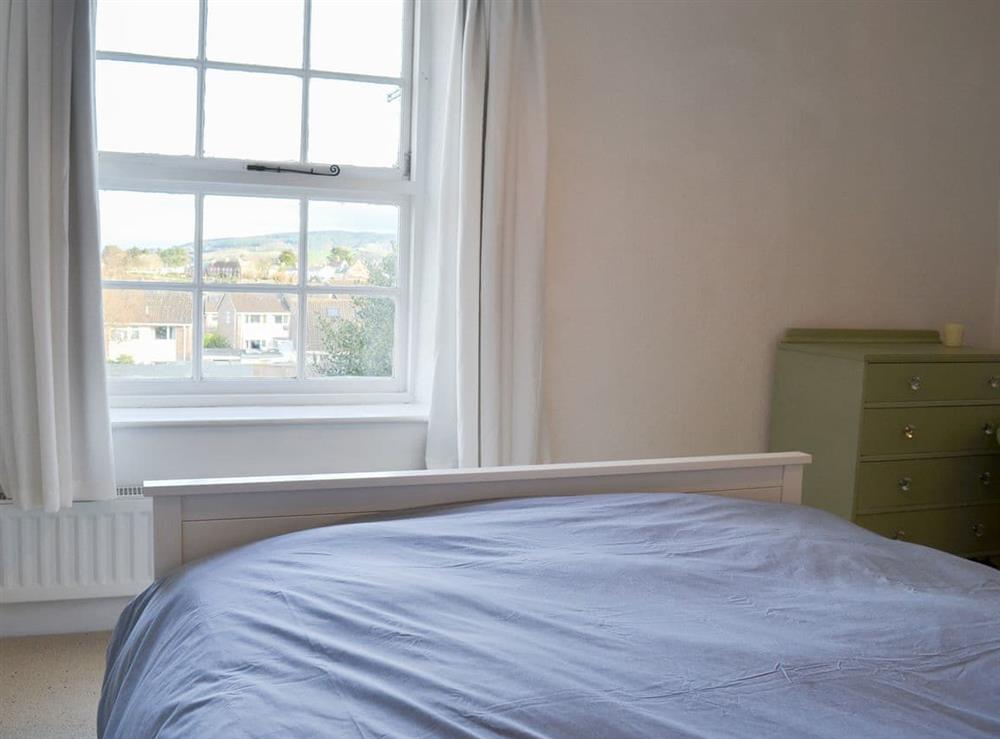 Charming bedroom with sash windows affording a lovely view at Honeysuckle Cottage in Watchet, Somerset