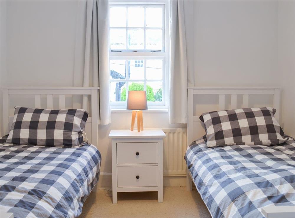 Pretty bedroom with twin single beds at Honeysuckle Cottage in Watchet, Somerset