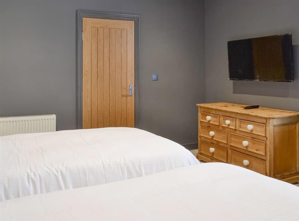 Twin bedroom with wall-mounted TV at Hope Apartment in Filey, North Yorkshire