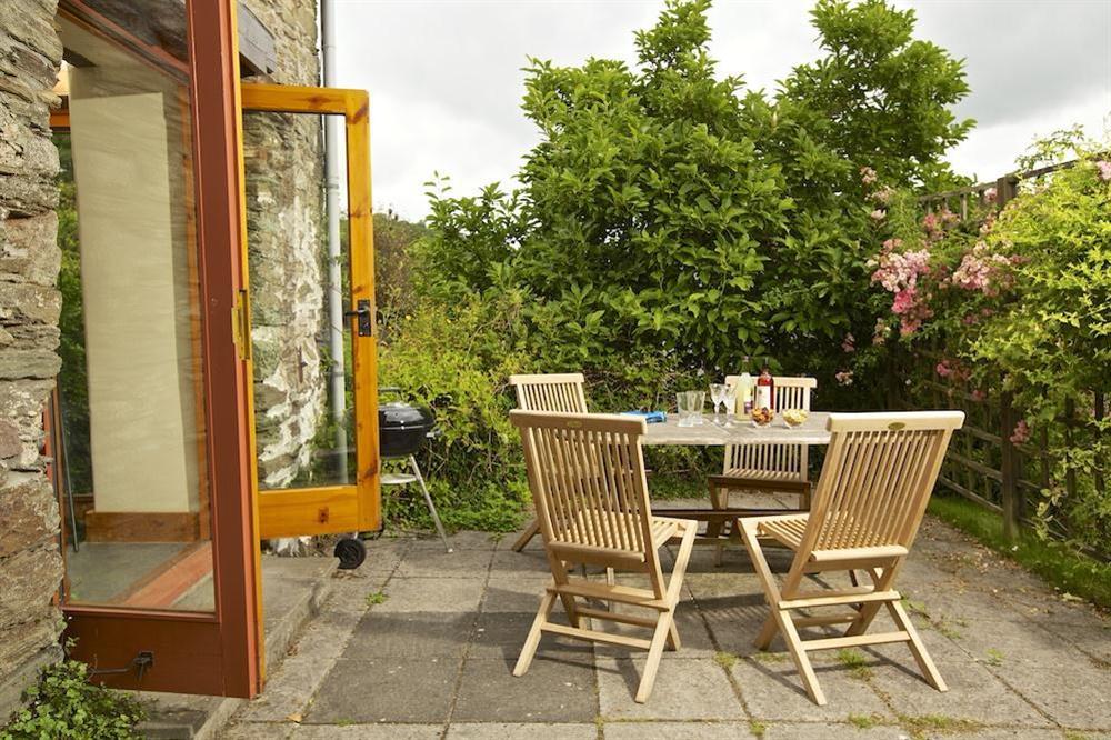 French doors from the hallway lead to a paved patio with garden furniture and barbecue at Hope Cottage (Loddiswell) in Loddiswell, Nr Kingsbridge