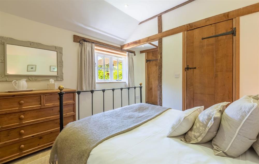 Charming double bedroom with beautiful cast iron bed and views across the garden at Hope Cottage, Henfield