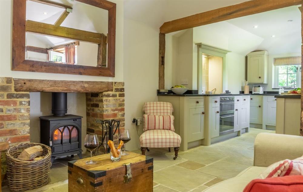 Open plan living area with wood burner and original oak beams at Hope Cottage, Henfield