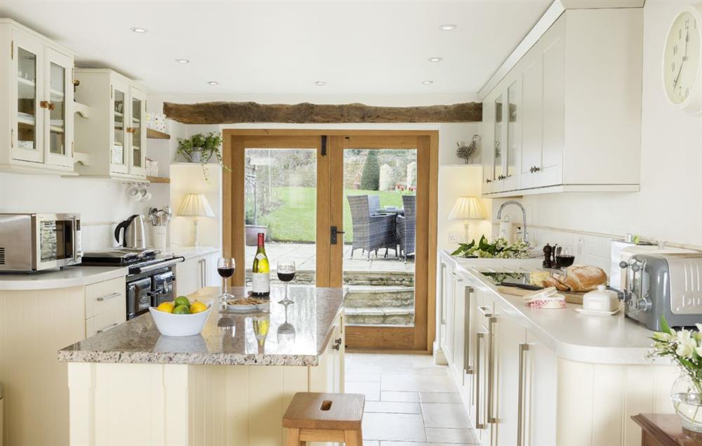 Kitchen with French doors to the garden and outdoor dining area at Hope Cottage, Quenington