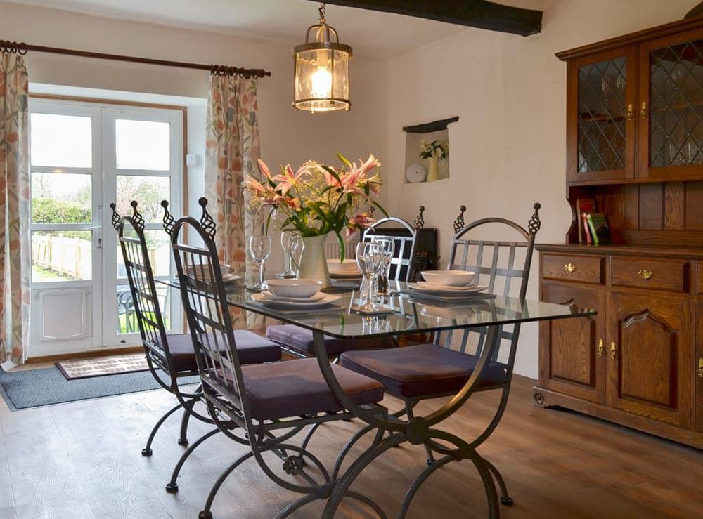 Cosy dining area with electric wood burner at Hopedene Cottage in Weare, near Axbridge, Somerset