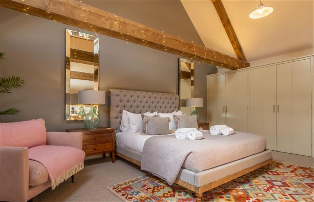Bedroom one with a 6’ super-king size bed at Horse Yard Barn, Warham