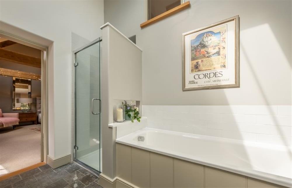 Bedroom one’s en-suite with bath and separate shower at Horse Yard Barn, Warham