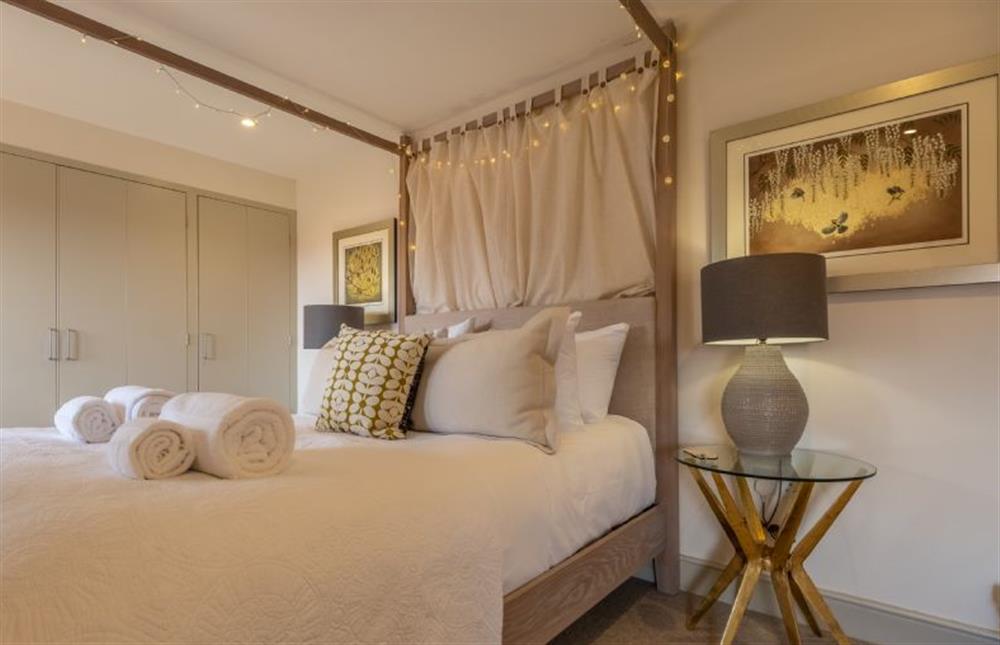 Bedroom two with a luxurious 5’ king-size four poster bed at Horse Yard Barn, Warham