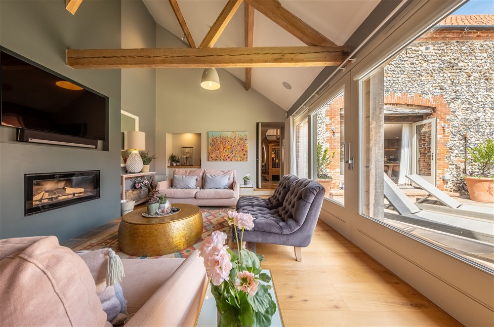 Sitting room with wood burning stove and bi-fold doors to outdoors at Horse Yard Barn, Warham