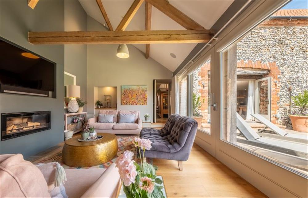 The sitting room has sliding glazed doors to let the outside in at Horse Yard Barn, Warham