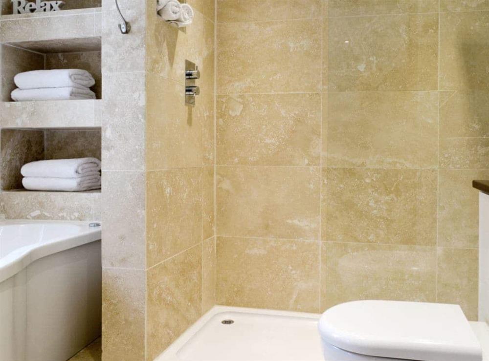 Fully tiled bathroom with separate bath and shower area at Florina, 