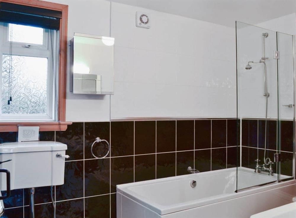 Stylish bathroom with shower over the bath at Horsepark Cottage in Gatehouse of Fleet, Kirkcudbrightshire