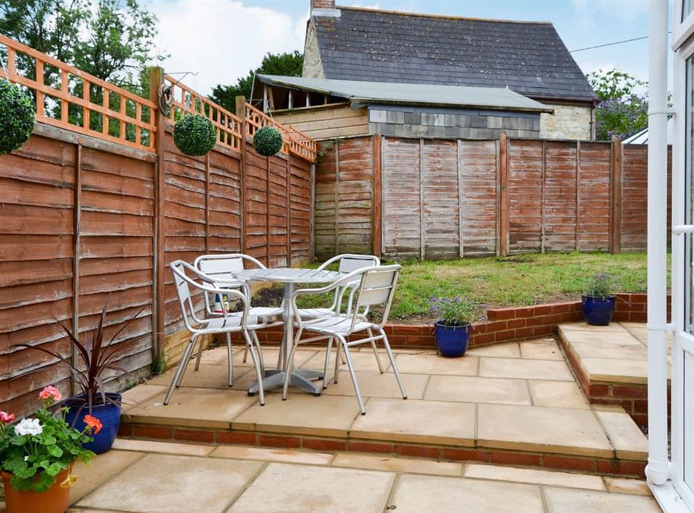 Enclosed lawned garden with sitting-out area and garden furniture at Horseshoe Cottage in Porchfield, near Cowes, Isle of Wight, England