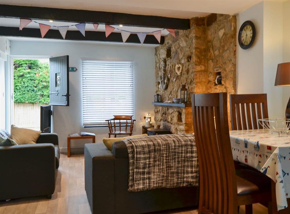Living and dining area with wood burner at Horseshoe Cottage in Porchfield, near Cowes, Isle of Wight, England