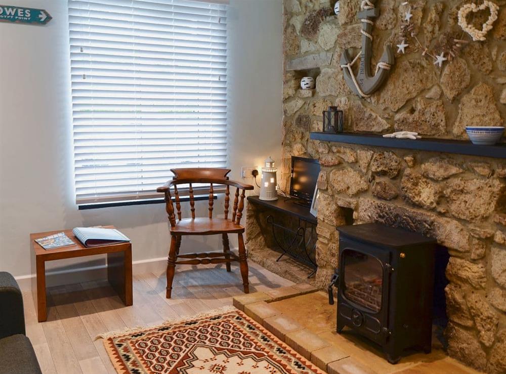 Living area with wood burner at Horseshoe Cottage in Porchfield, near Cowes, Isle of Wight, England