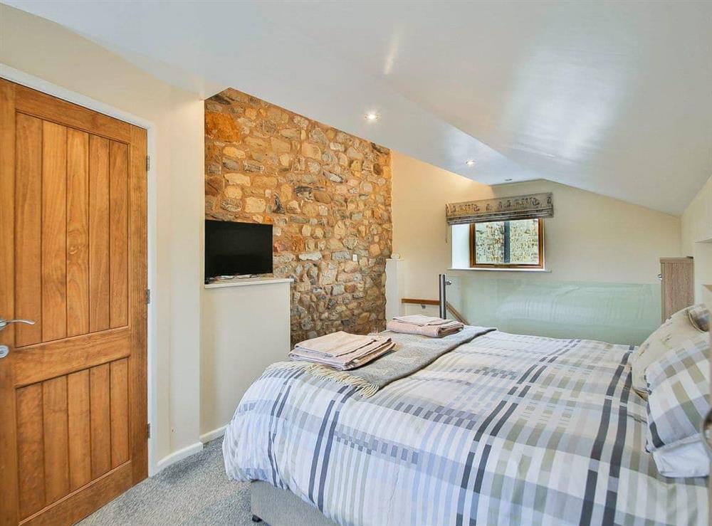 Double bedroom with exposed stone wall at Horseshoe Cottage in Sawley, near Clitheroe, Lancashire