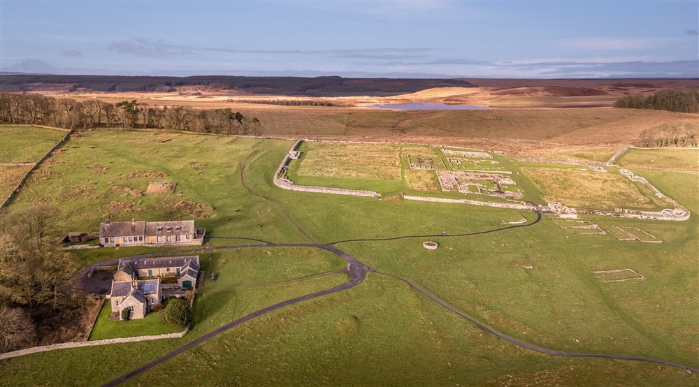 An aerial view of Housesteads, showing the close proximity to the museum, Hadrians Wall and the Roman Fort, with Broomlee Lough in the distance, Northumberland at Housesteads in Hexham, Northumberland
