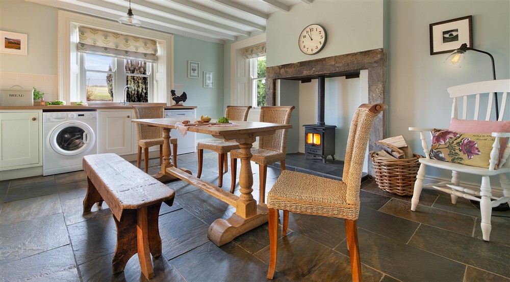 The open-plan kitchen and dining room with inglenook and multi-fuel stove at Housesteads in Hexham, Northumberland