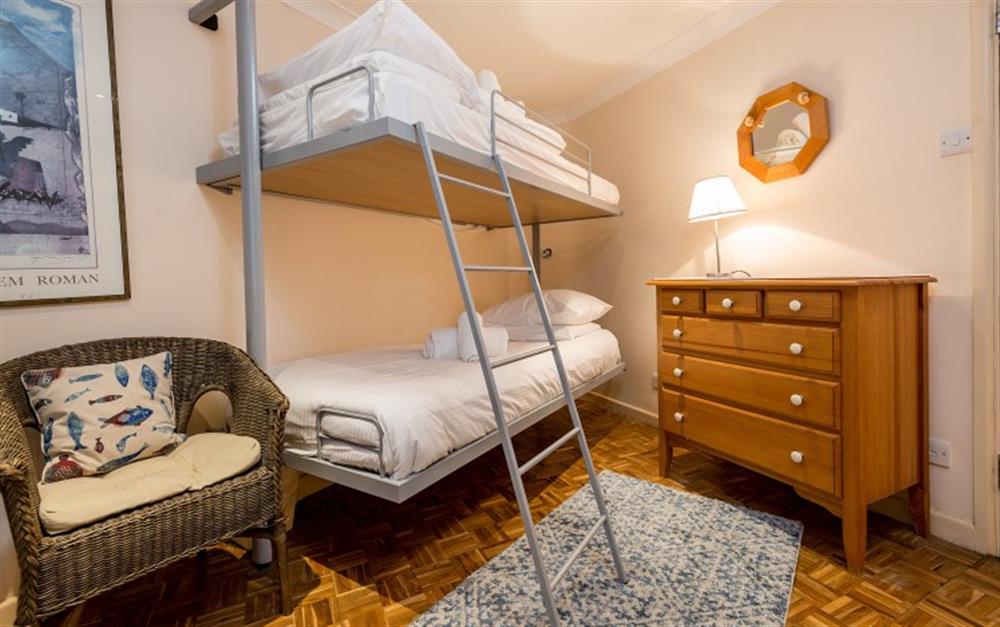The bunk room is spacious and decorated in neutral tones.