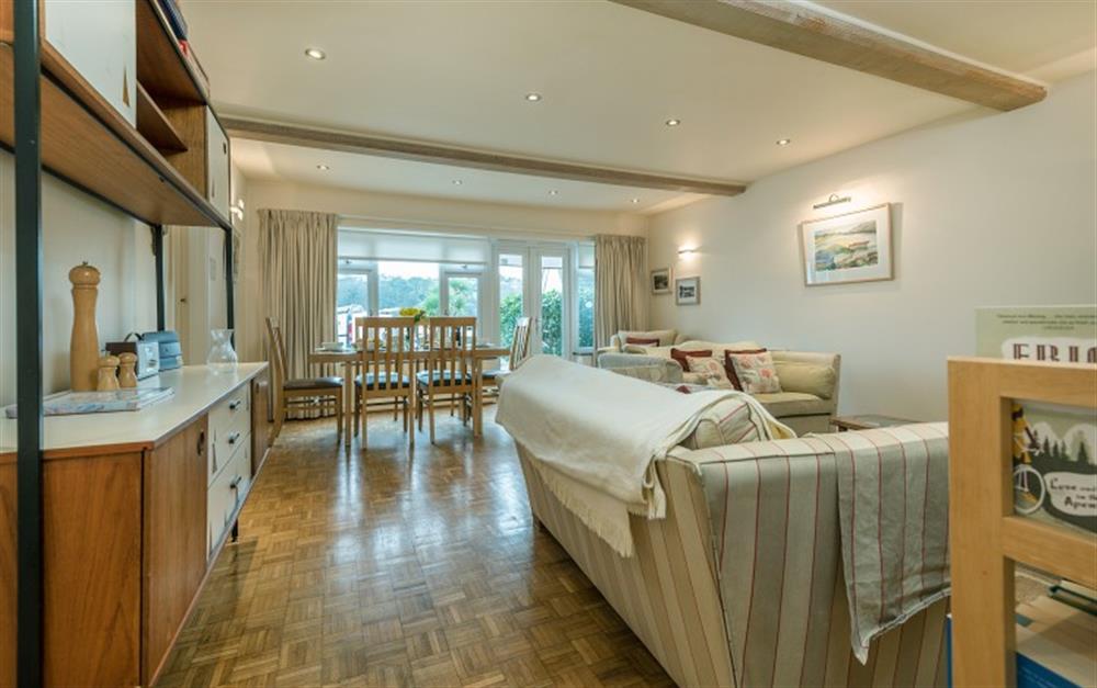 The large dining table is situated to enjoy the views of the beach and Helford River. at Hove To in Helford Passage