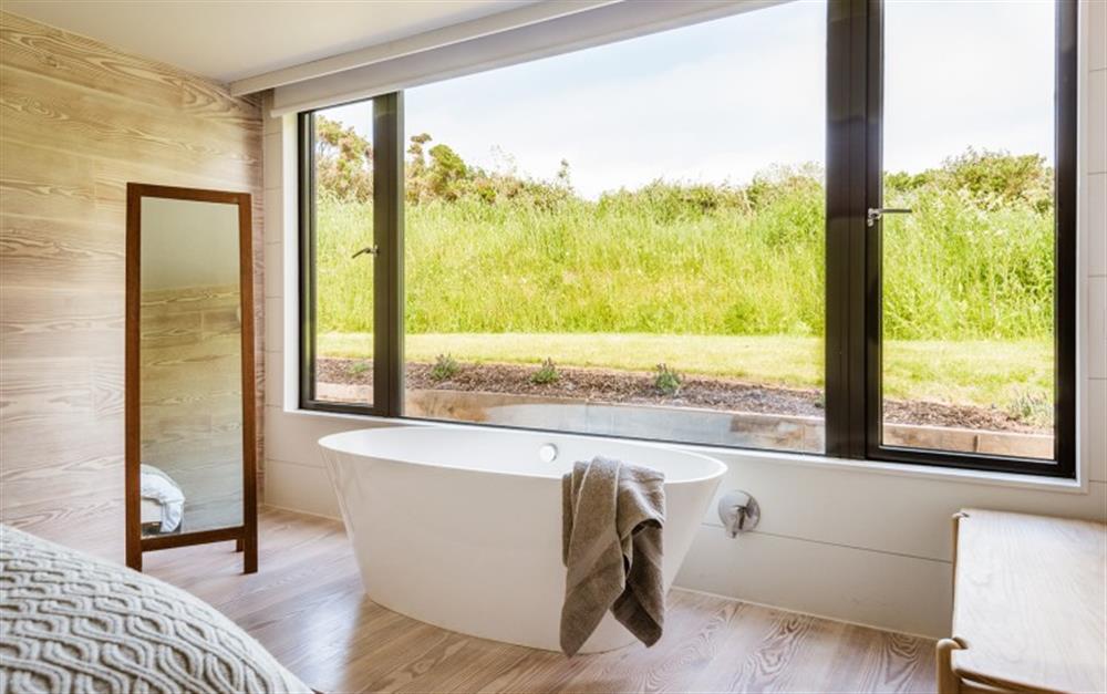 A freestanding bath sits in the master bedroom window at Huccombe Farmhouse in Beesands