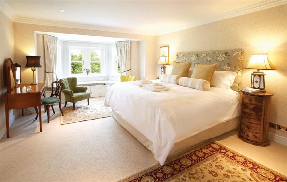 Bedroom one with a 6’ super-king size bed and en-suite bathroom at Hunter Court, Clanfield
