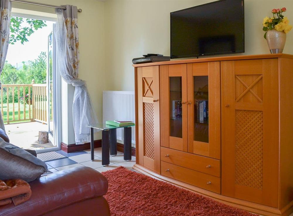 Living room with patio doors at Hunters Cottage in Y Ffôr, near Pwllheli, Gwynedd