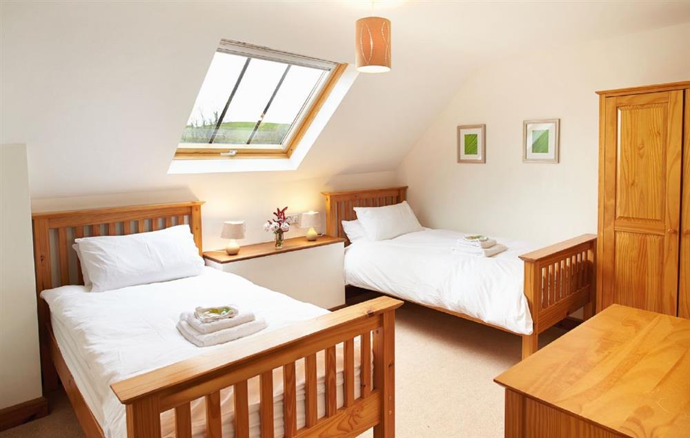 Twin bedroom with 3’ beds and en-suite bathroom with shower over bath at Hunters Moon, Feniton