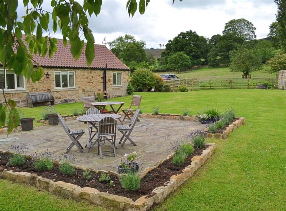 Garden with paved seating area at Knayton Moor Cottages, 