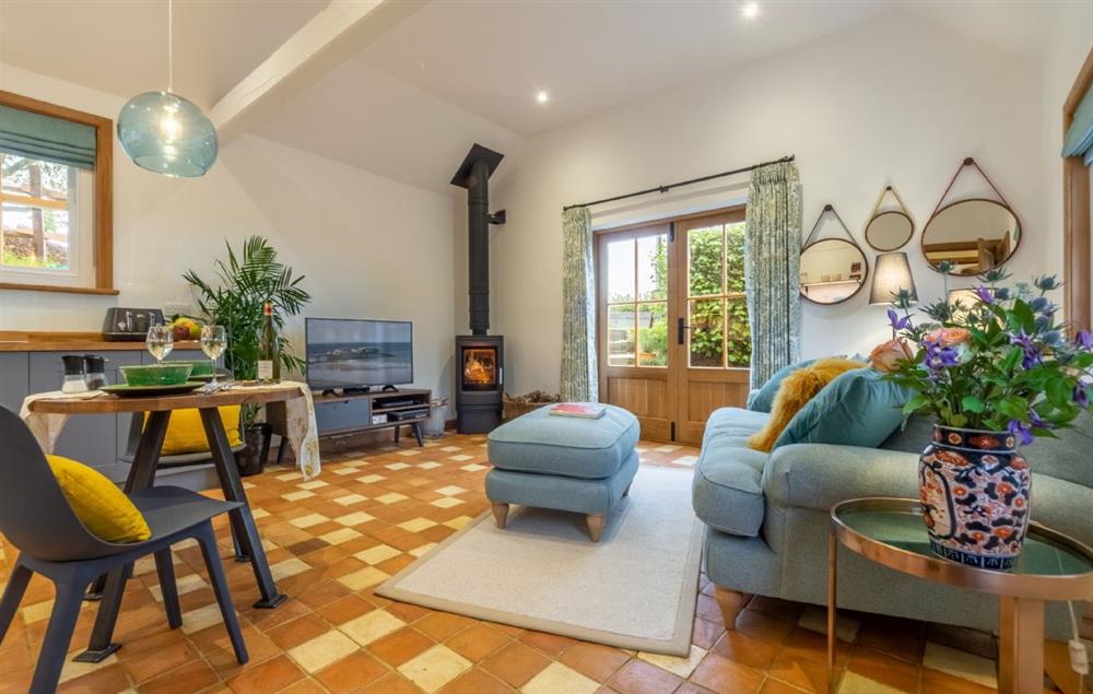 Open-plan sitting room with wood burning stove and french doors leading to the garden at Inkpen Cottage, Robertsbridge