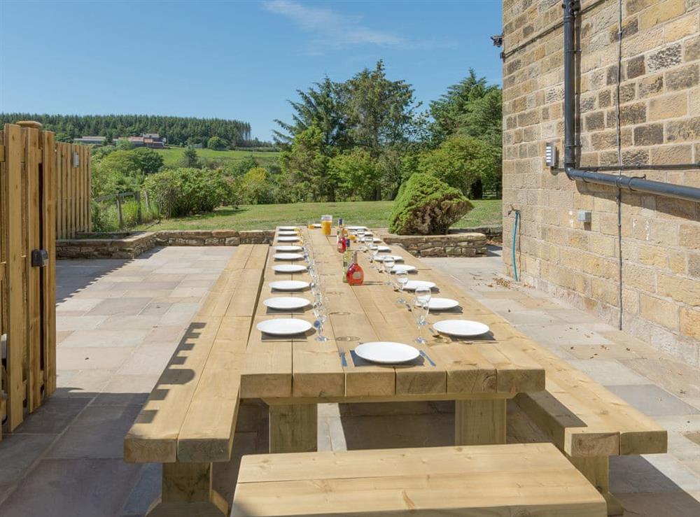 Patio area with outdoor dining furniture at Island Farm House in Staintondale, near Whitby, North Yorkshire