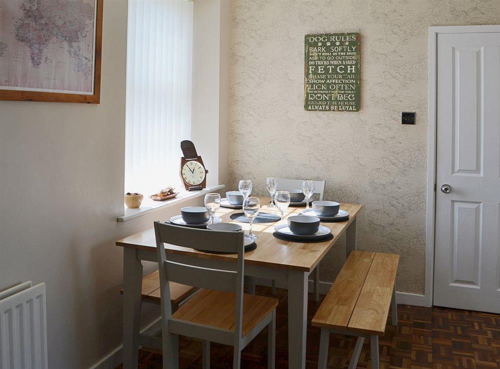 The dining area has a family dining table with bench seating at Island View in Amble, Northumberland