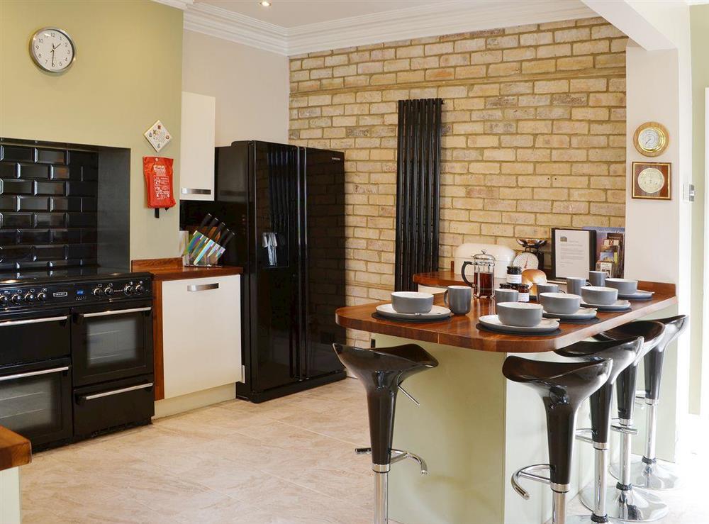 The feature brick wall, American style fridge freezer and range cooker gives the kitchen a professional fell at Island View in Amble, Northumberland