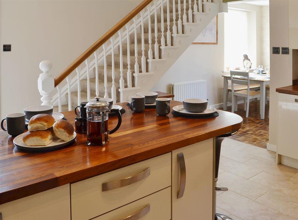 The spacious dining/kitchen area has a wood-topped breakfast bar at Island View in Amble, Northumberland