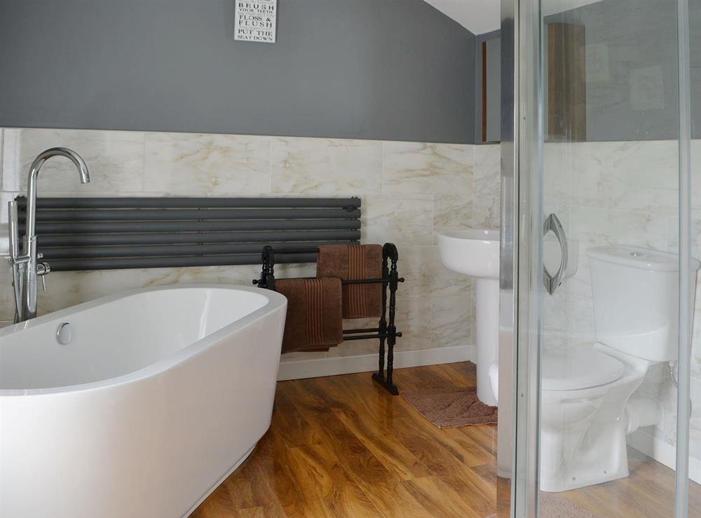 The stylish modern bathroom has a standalone bath and walk-in shower at Island View in Amble, Northumberland
