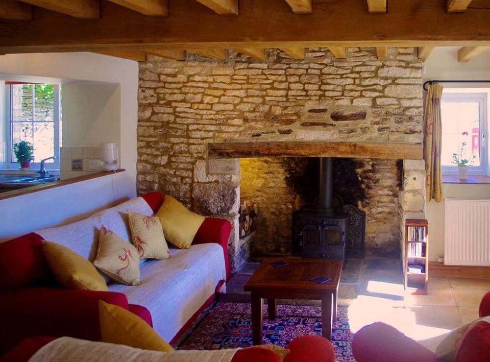 Beamed living room with feature fireplace at Ivy Cottage in Chedworth, near Cheltenham, Gloucestershire