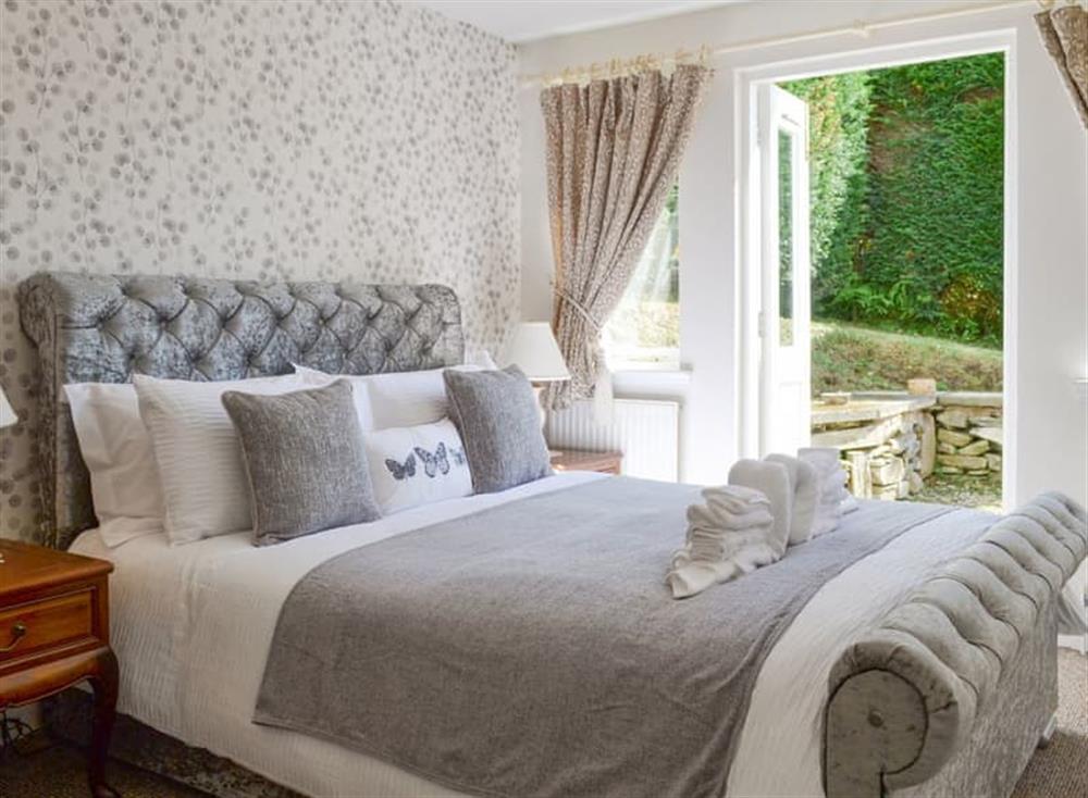 Relaxing en-suite double bedroom with doors to garden at Ivy Cottage in Kilcreggan, near Helensburgh, Dumbartonshire