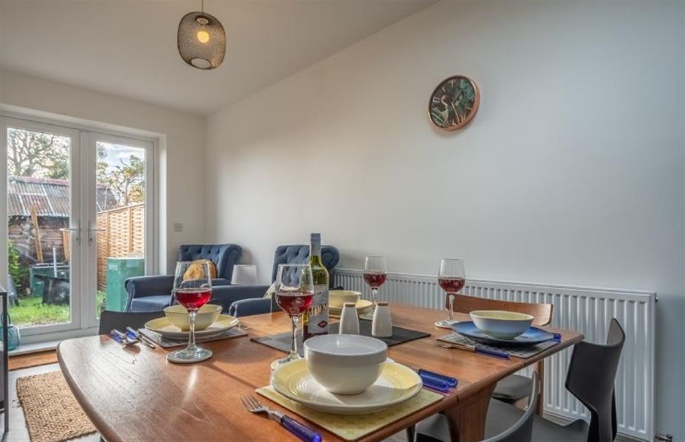 Dining area with seating for guests and French doors leading to the garden at Ivy Cottages, Darsham